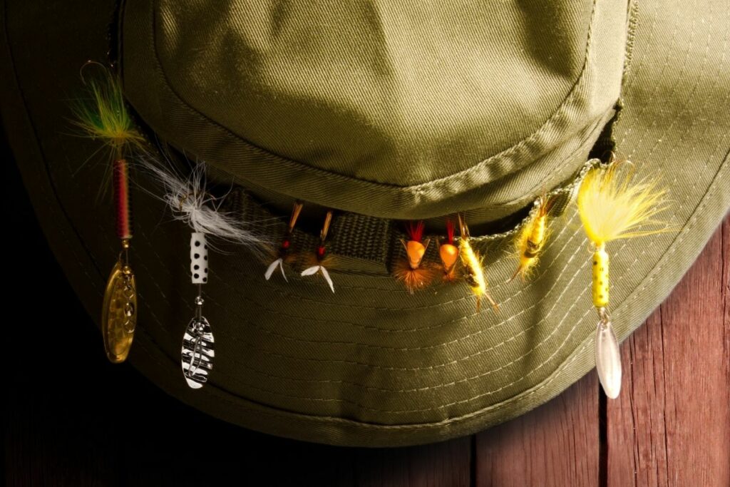 a photo of a hat with fishing hooks attached to show why do anglers put fishing hooks on their hats