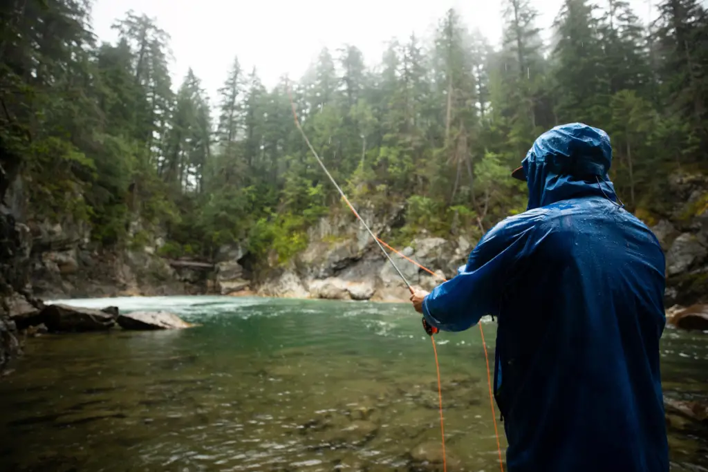a photo of an angler fishing in the rain to sow that trout do bite in the rain