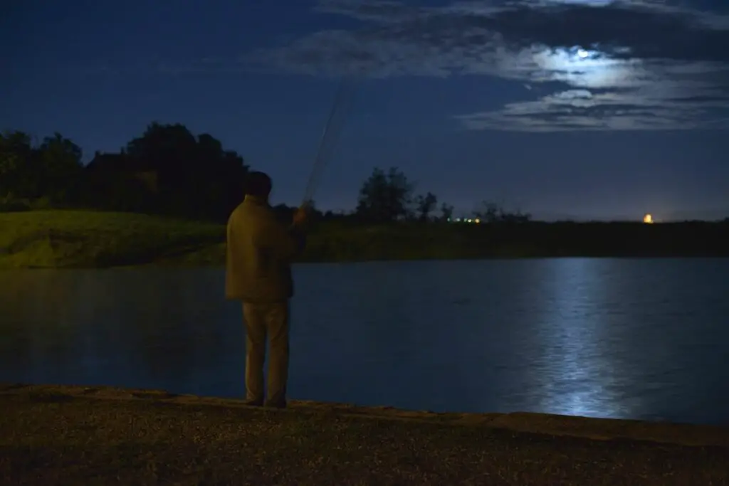 a photo of an angler fishing at nigh to show that trout do bite at night
