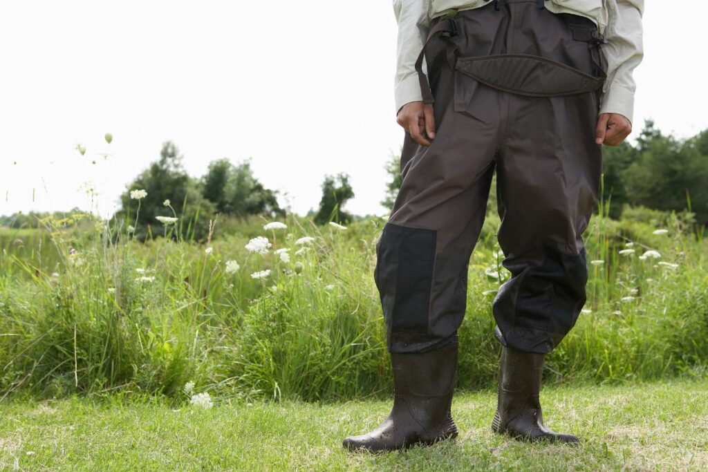 a photo of a man wearing waders to show can you wear waders on a kayak
