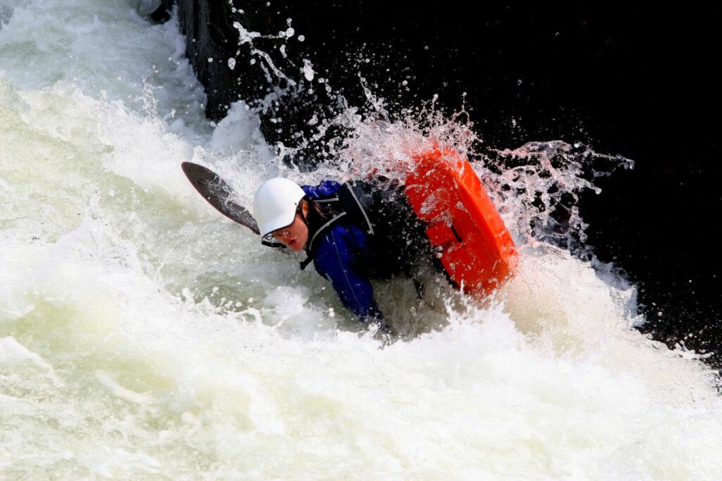 a photo of a kayak capsizing to answer can you get stuck in a kayak if it flips over? 