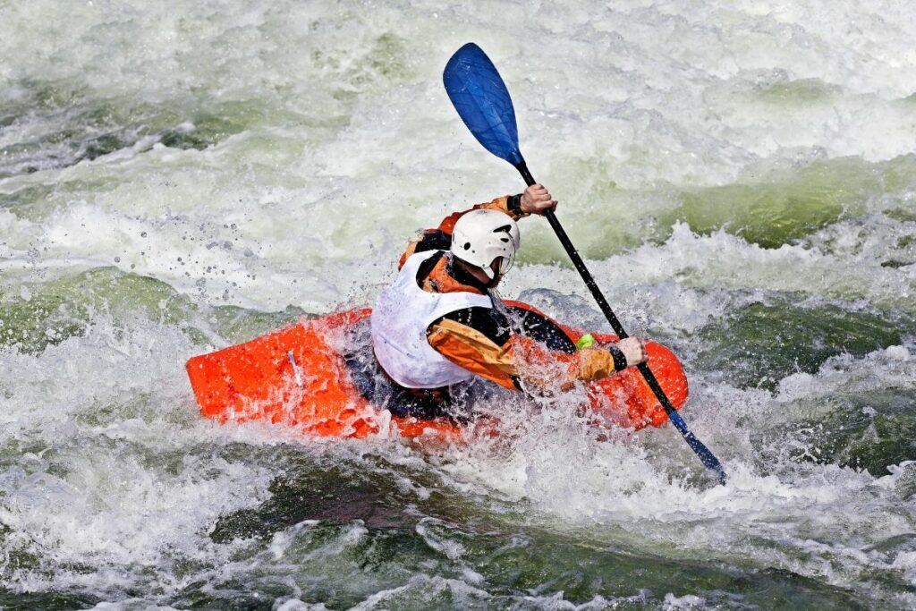 a photo of kayaker paddling in rough water conditions to show when not to kayak
