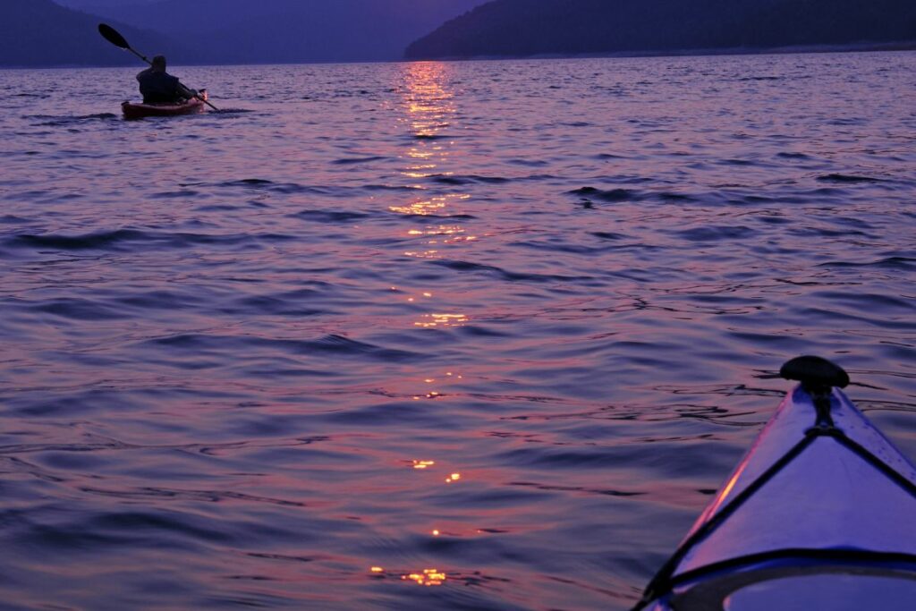 a photo of a paddler kayaking at night