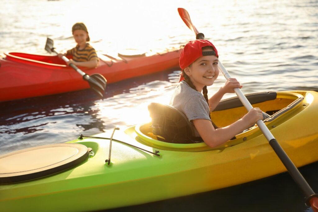 a photo of kids kayaking to show the benefits of donating and answer where can i donate a kayak