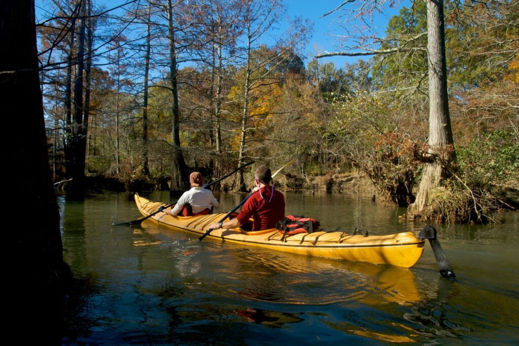 a photo of a tandem kayak to answer where does one person sit in a two-person kayak