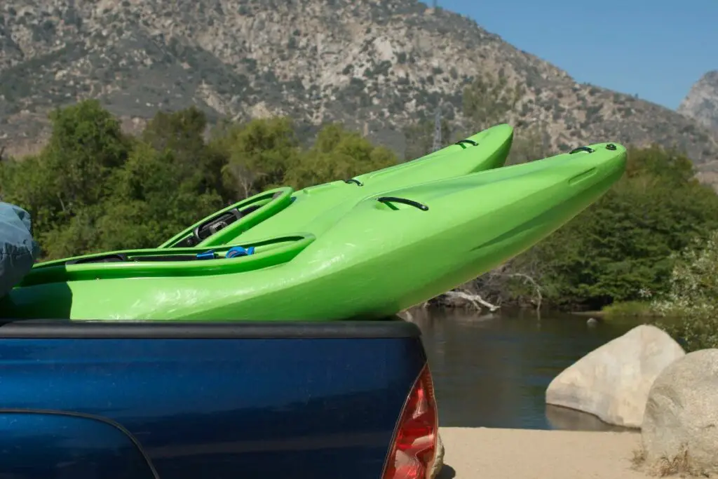 A photo of a kayak in a truck bed to show , how to transport a kayak in a truck